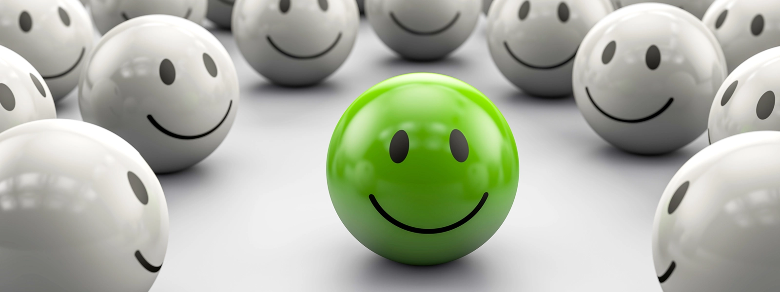 an illustration of a bunch of smiley faces surrounding a single green smiley face