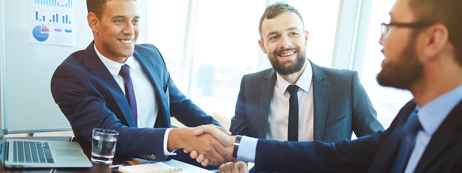 A young executive shakes hands after landing a deal