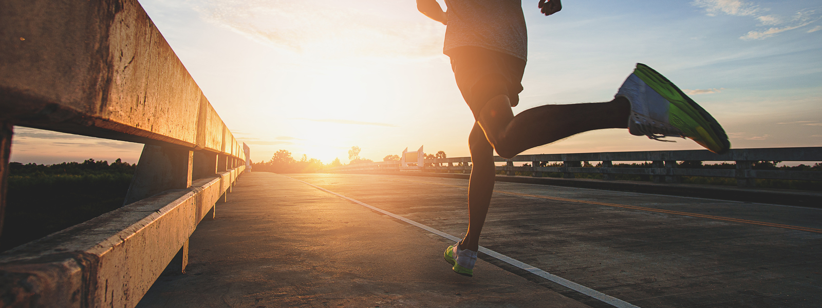A photo of a runner sprinting into the sunrise