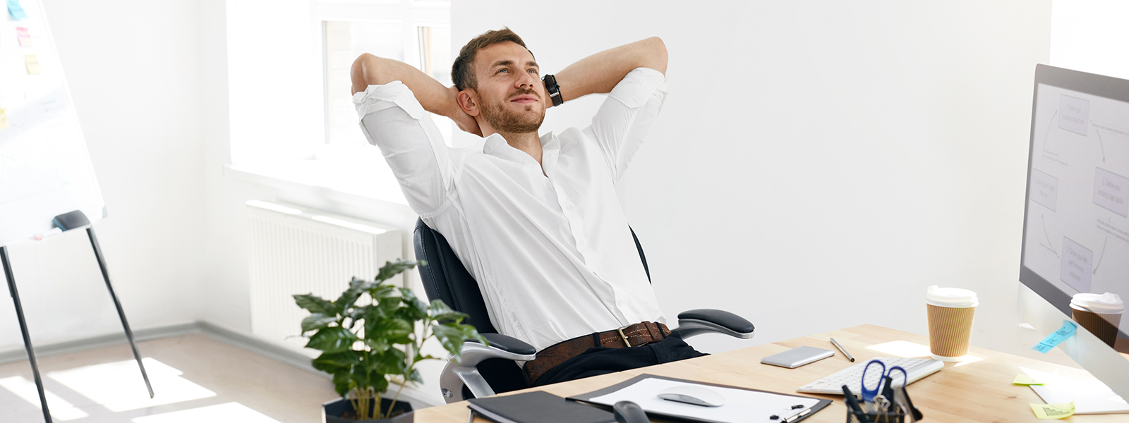 A guy in white shirt relaxing and thinking in office