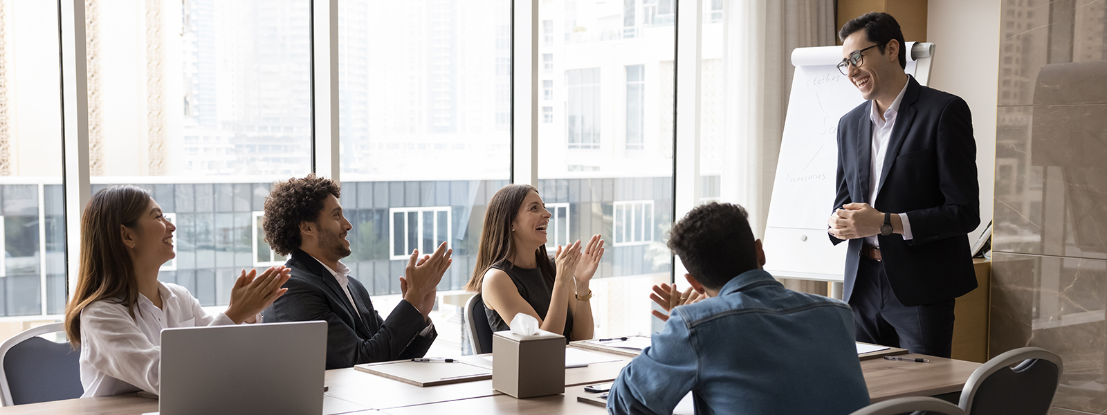 Corporate person in meeting while staff applaud