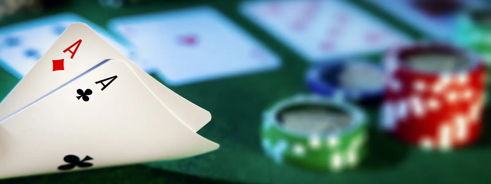 A photo of two aces in front of stacks of poker chips in the background