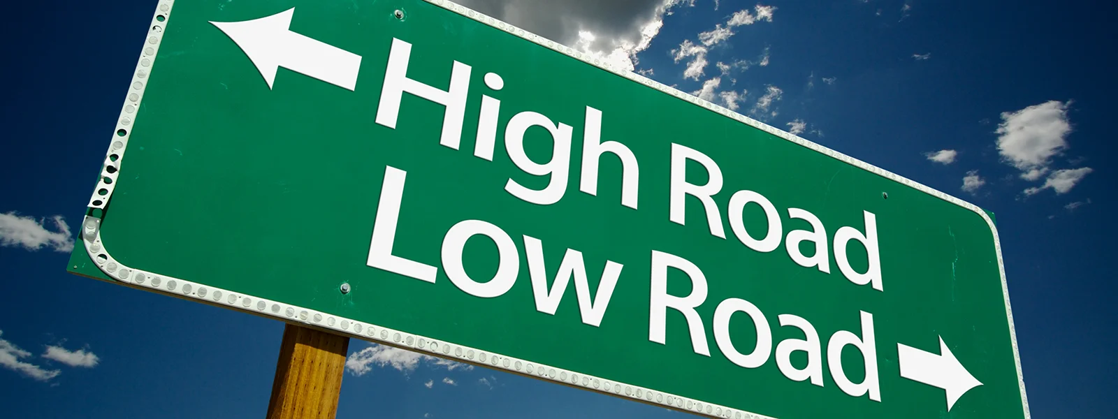 An illustration of a street sign giving directions to the high road and the low road