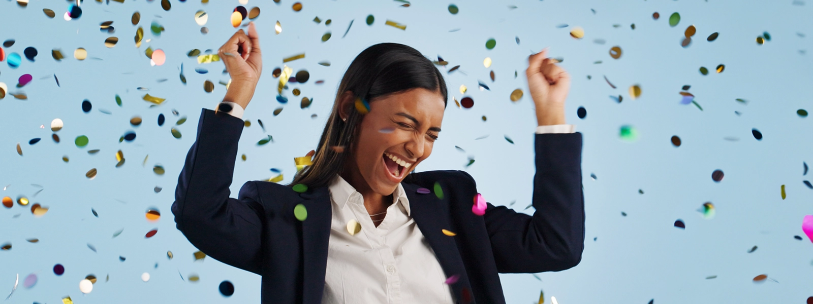 a photo of a cheering woman surrounded by falling confetti