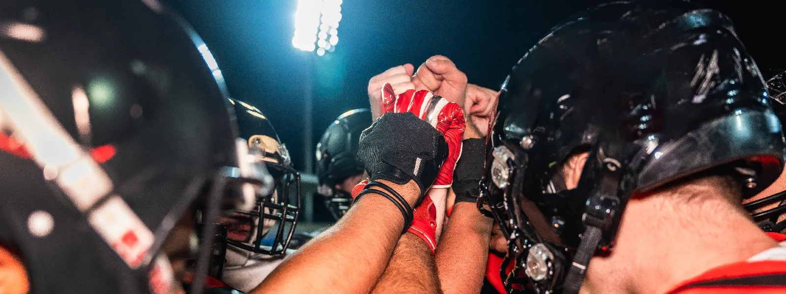 football players end a huddle with a fist bump